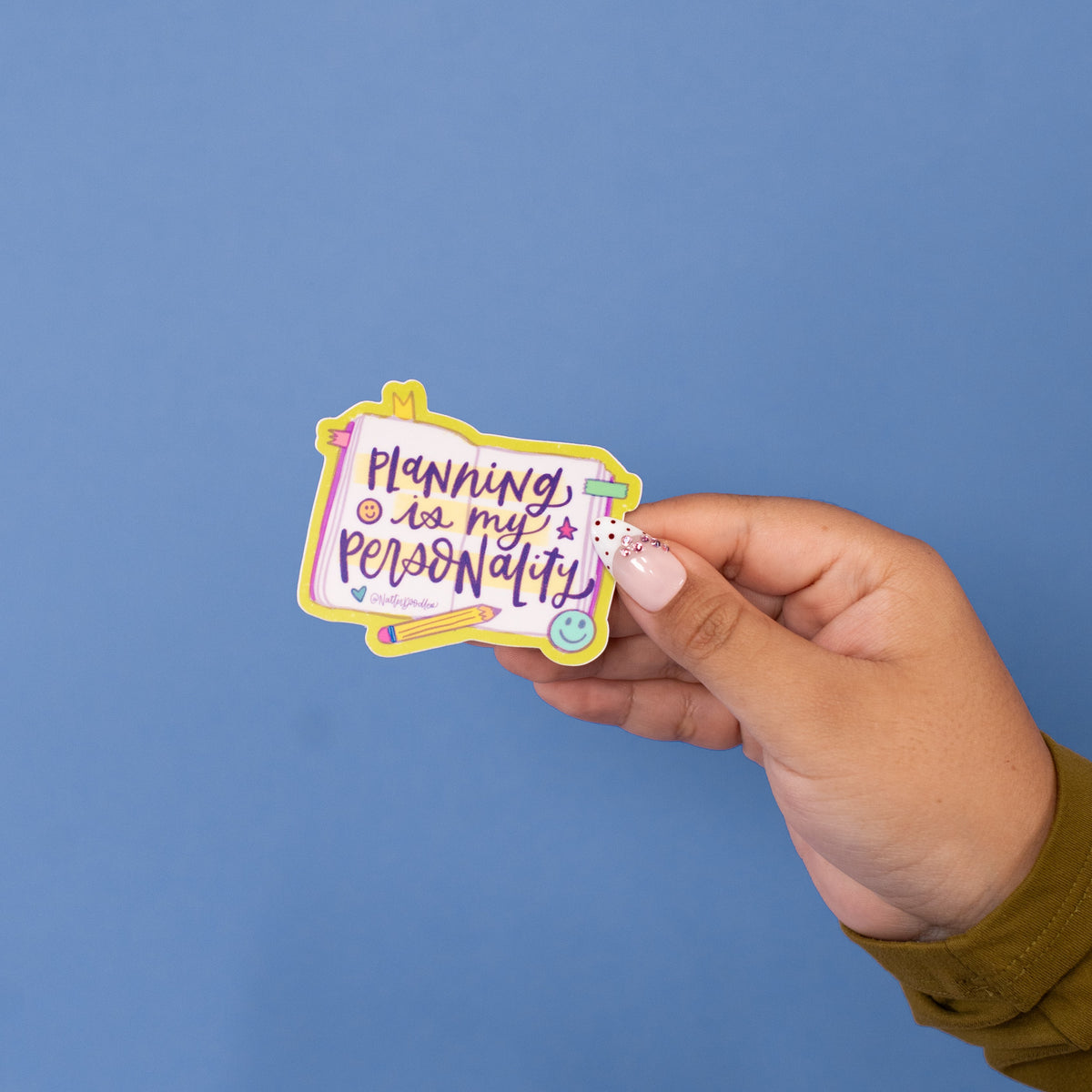 Planning Is My Personality vinyl sticker with purple hand lettering on an open planner page with a lime green border