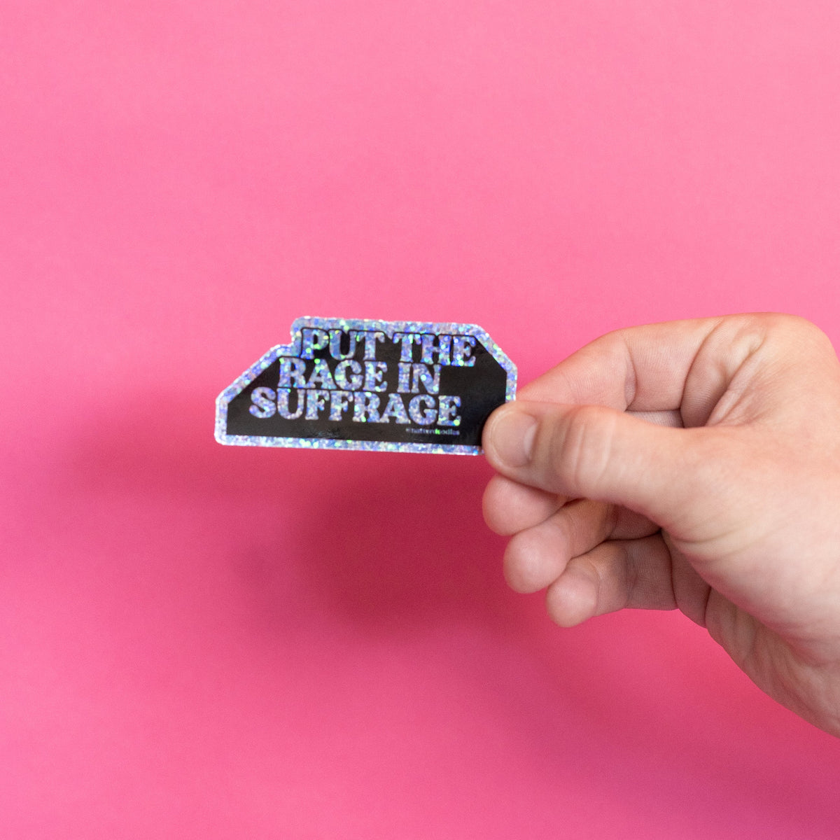 Put the Rage in Suffrage sticker held in hand to show 3 inch size