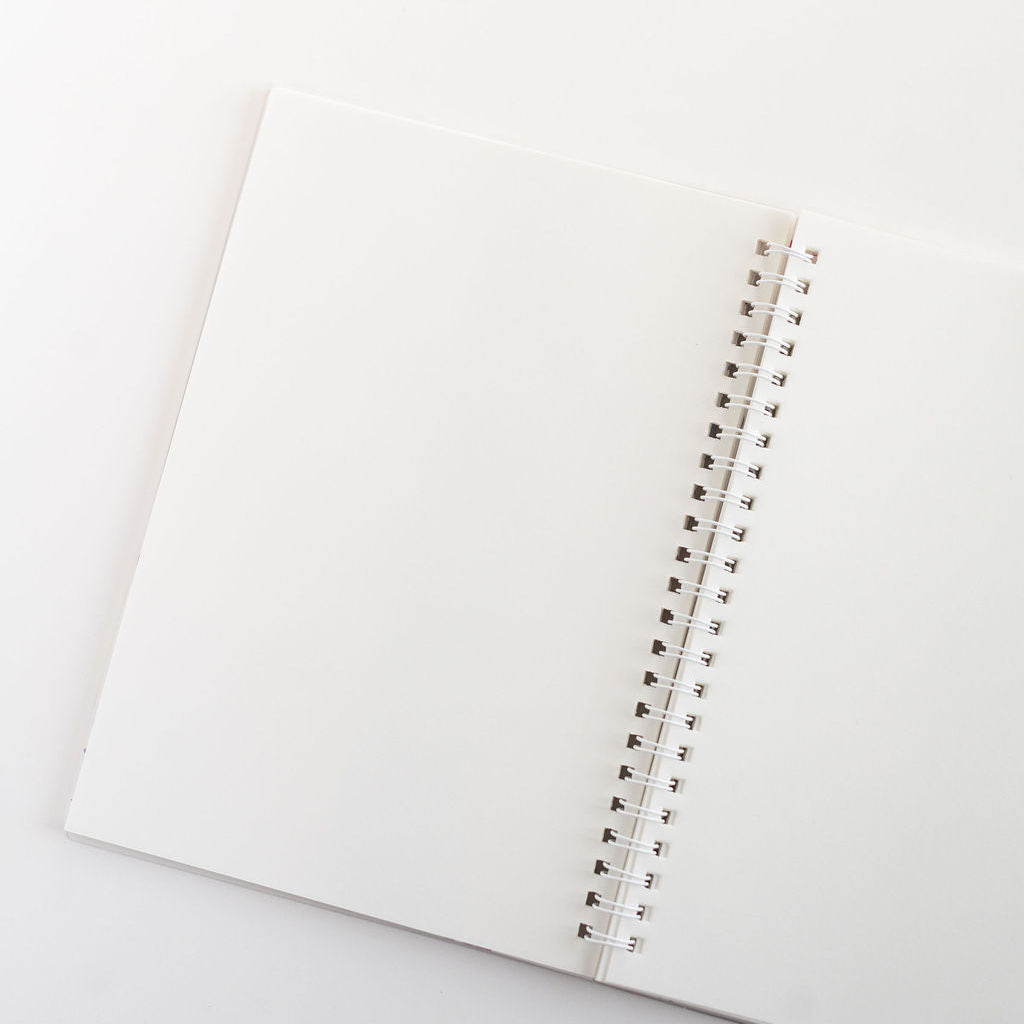 Open notebook with spiral binding on a light gray background
