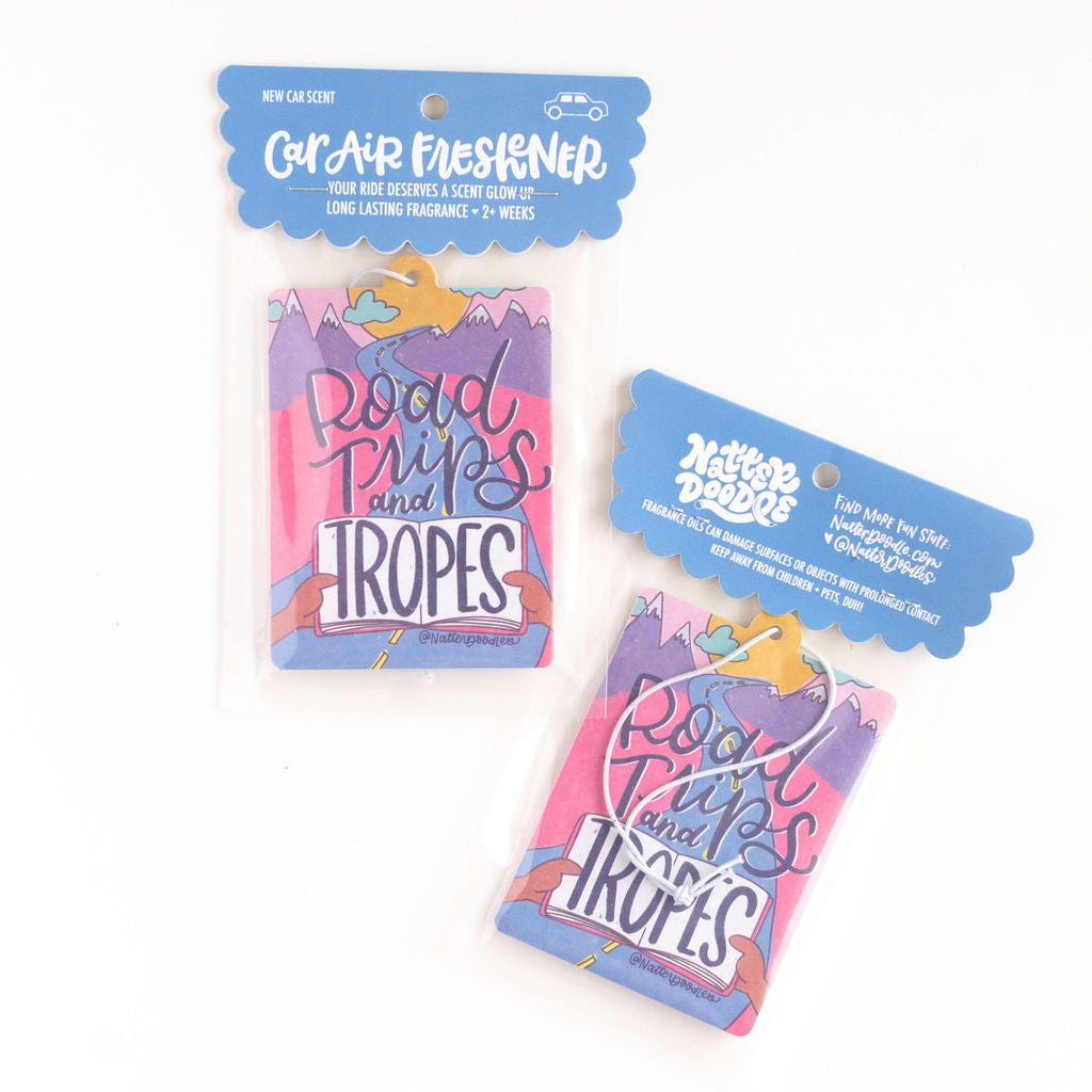 Two packages of car air fresheners that say road trips and tropes