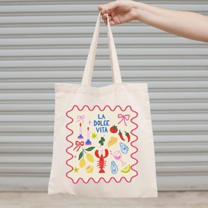 Tote bag with 'La Dolce Vita' design held by a hand against a neutral background