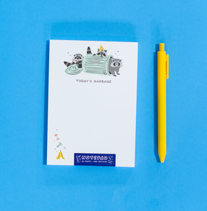 Notepad with raccoon illustrations and a yellow pen on a blue background