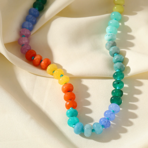 Colorful beaded bracelets on a white fabric background
