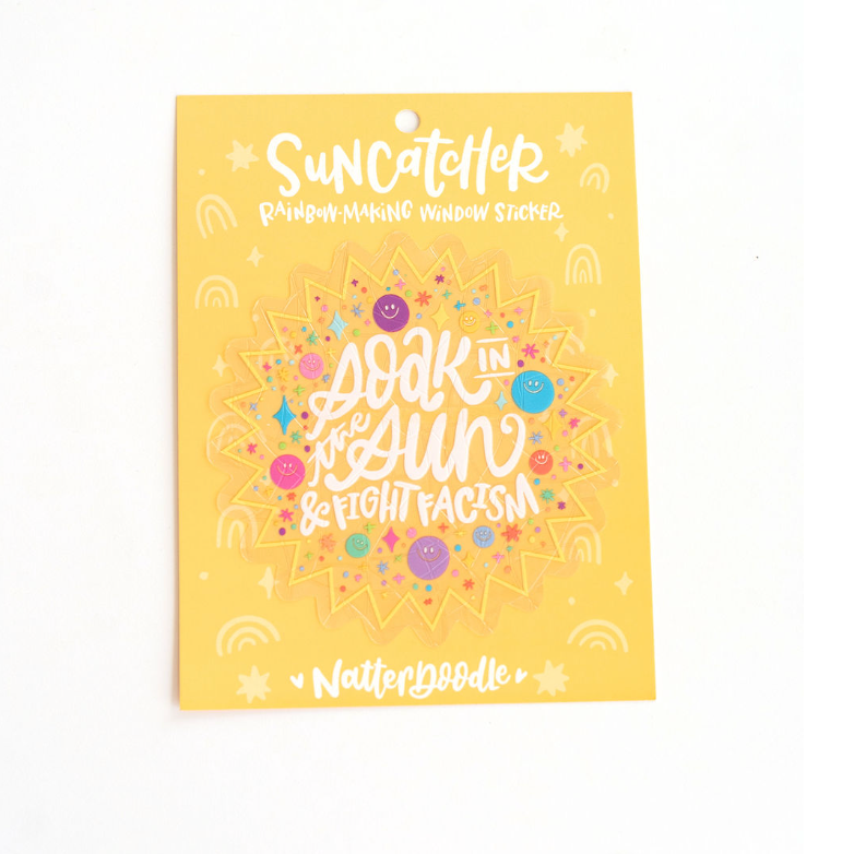 Yellow suncatcher craft kit packaging with colorful text and graphics on a white background