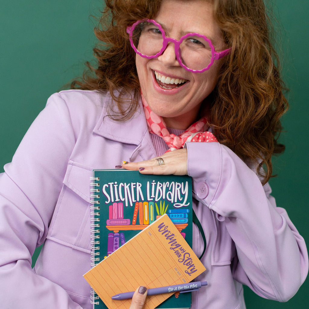 sticker library sticker book and orange notrepad held by woman