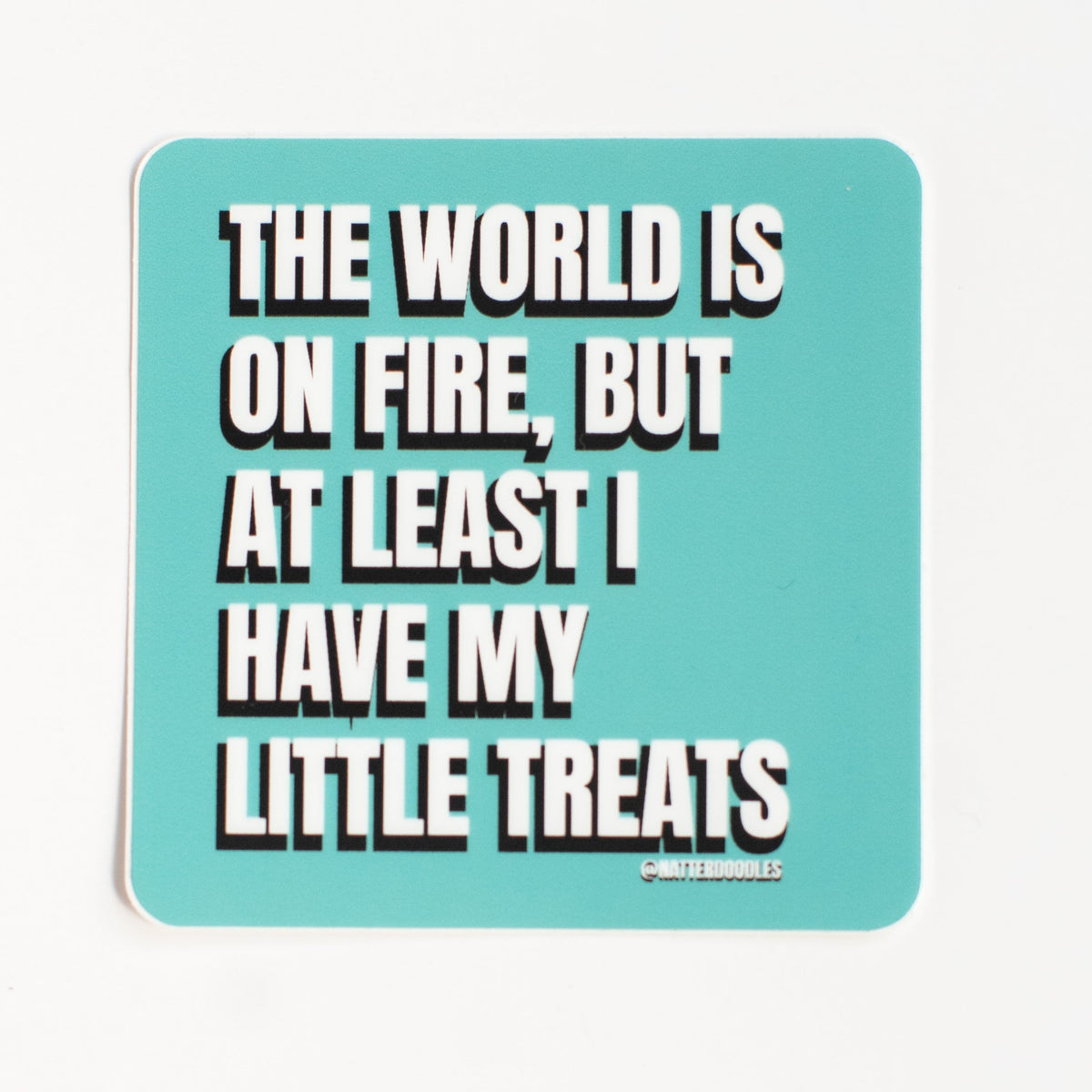 The World Is on Fire, but at Least I Have My Little Treats vinyl sticker with white lettering on a turquoise background