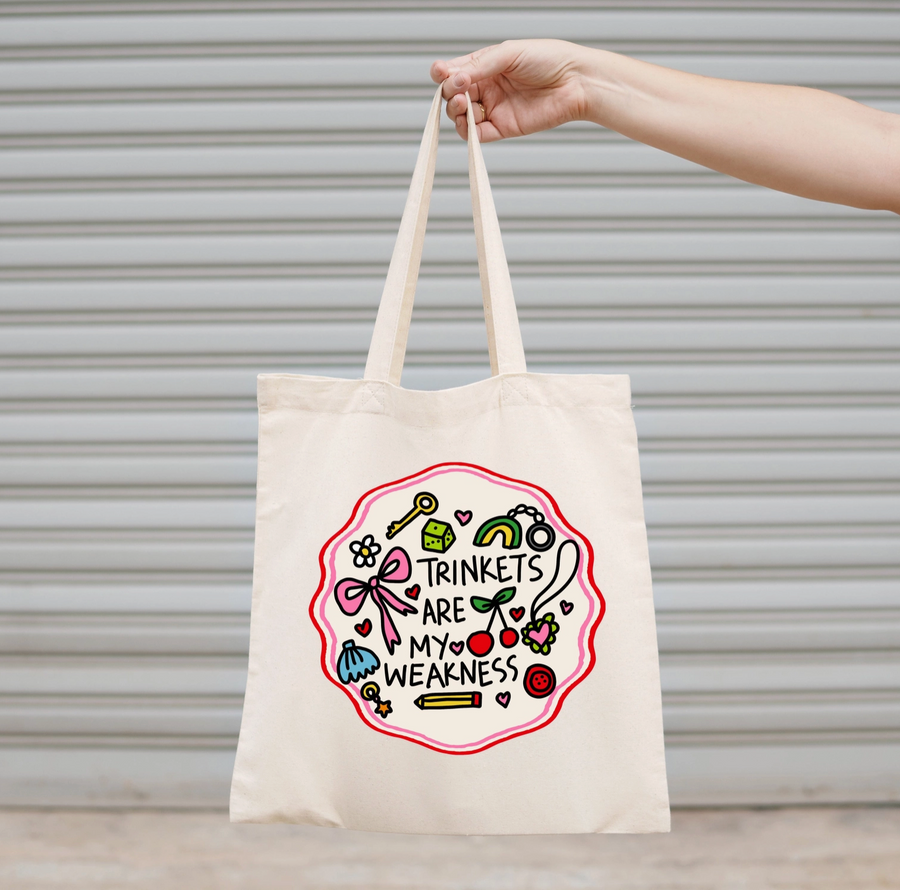 White tote bag with decorative text and illustrations on a yellow textured background