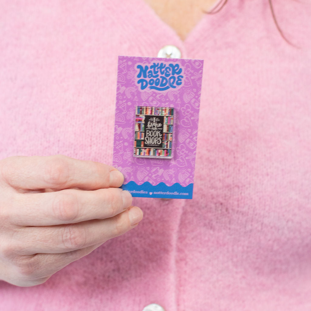 Person holding a badge with a purple card featuring 'Kitty Paddle' branding.