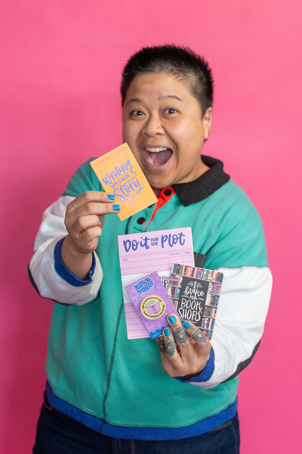 Person holding stationery against a pink background
