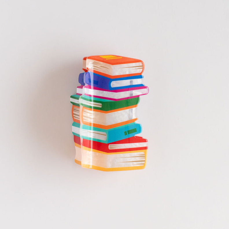 Stack of colorful books hair claw on a white background