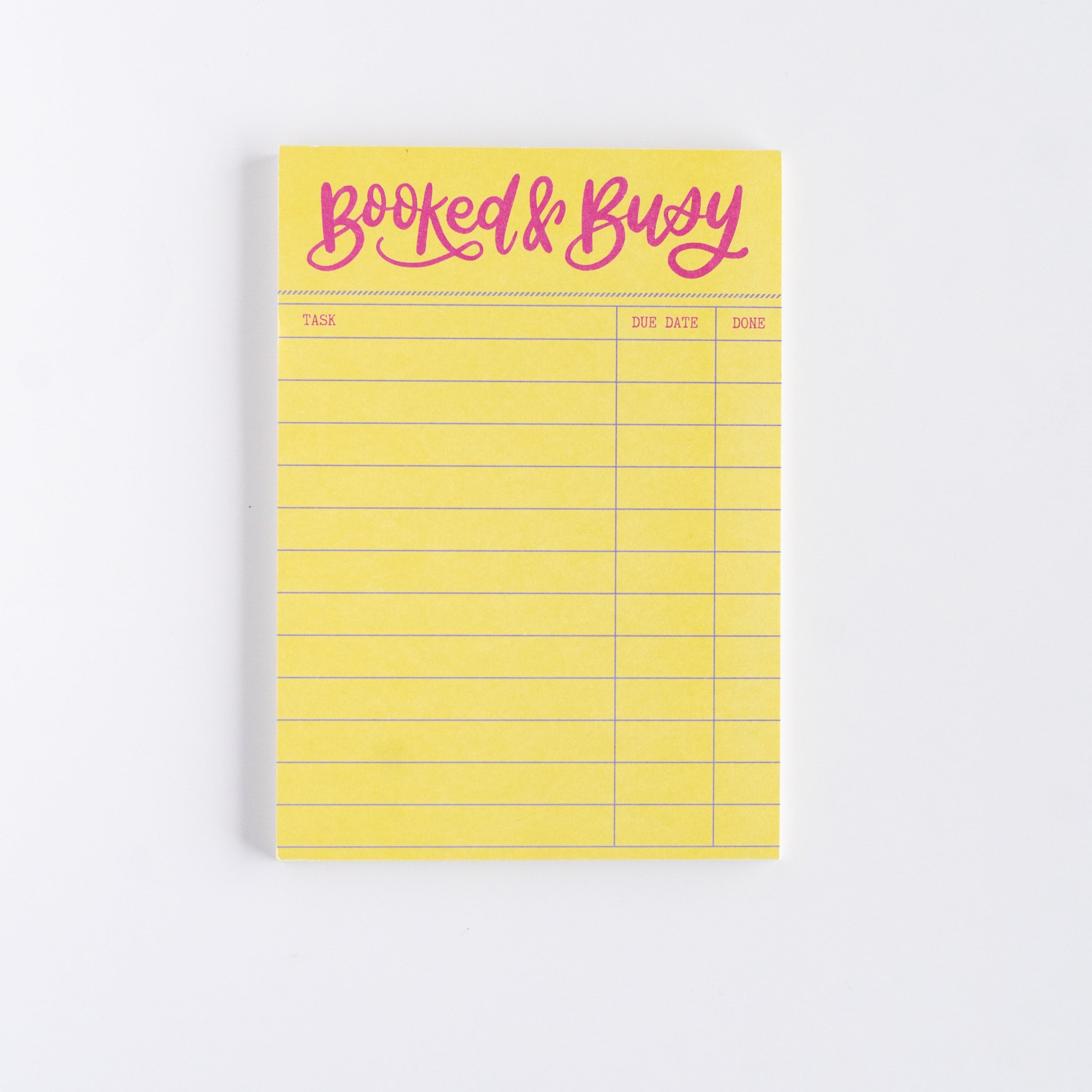 Yellow notepad with 'Booked & Busy' text on a white background