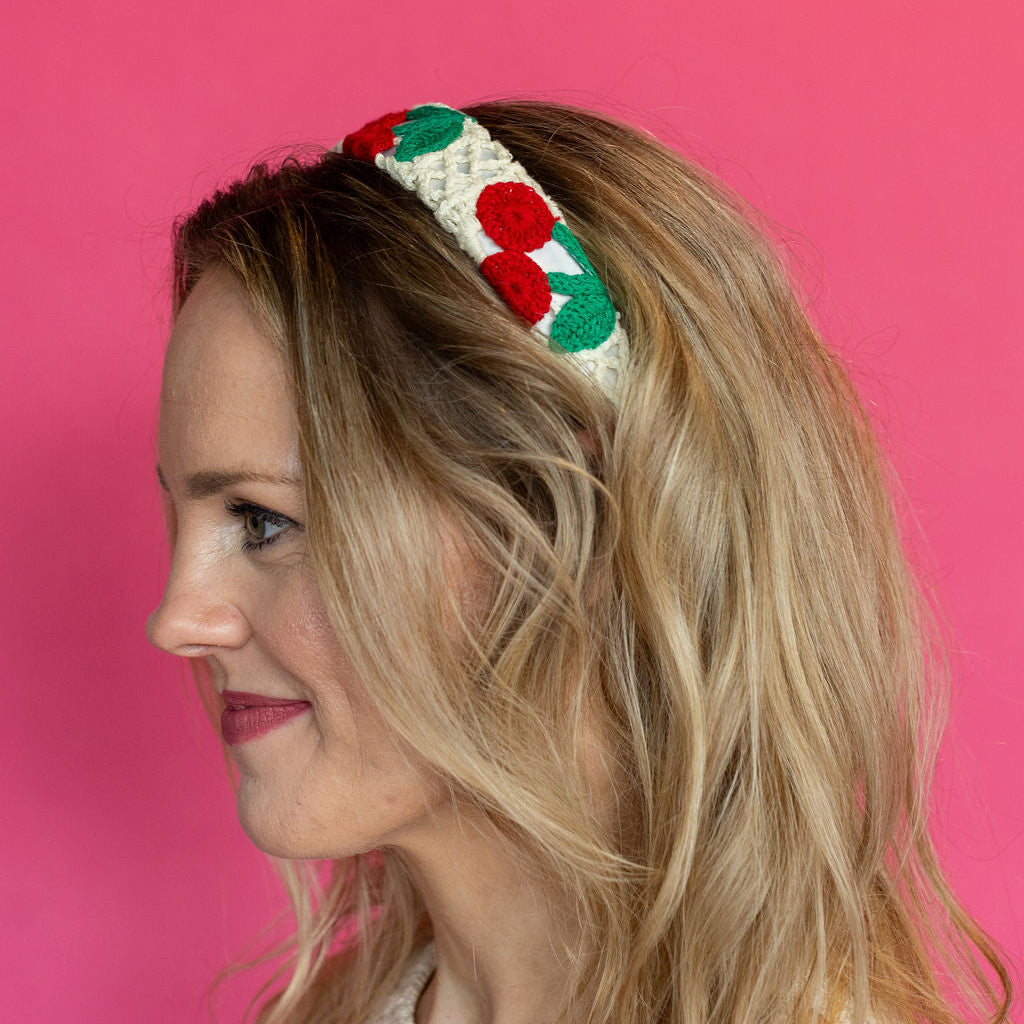 Woman wearing a colorful headband against a pink background