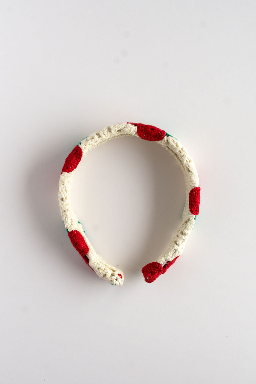 Headband with red cherry accents on a light gray background