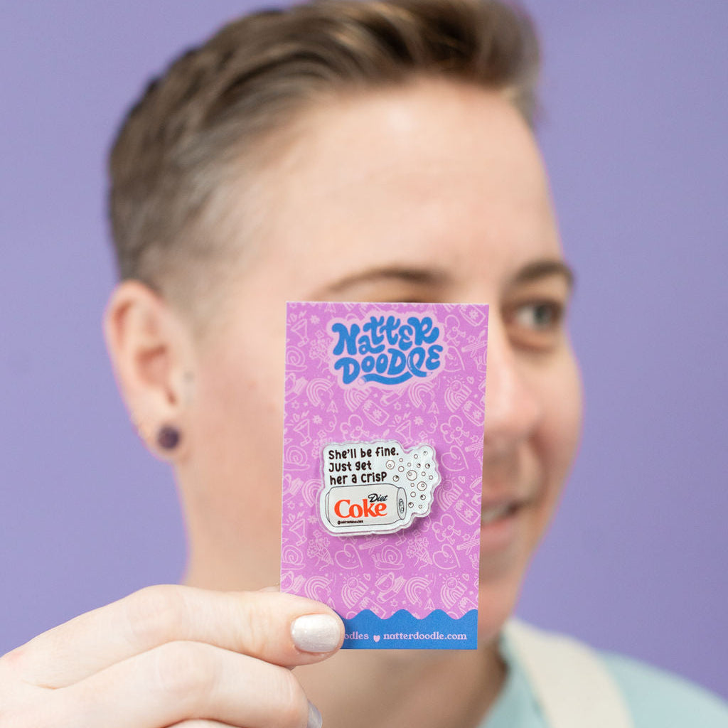 Person holding a purple card with diet coke pin on it