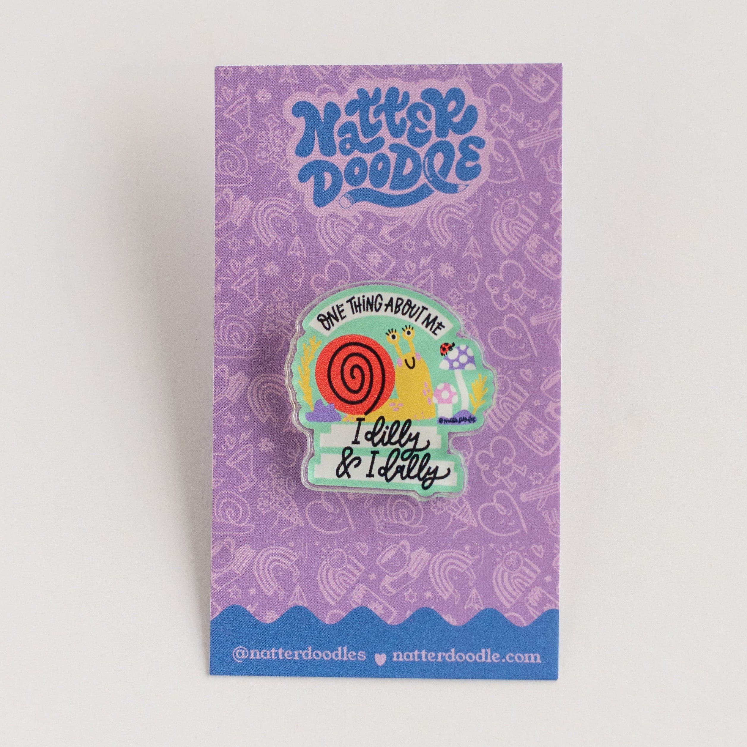 Colorful snaill-shaped pin on a purple card with 'NatterDoodle' branding.