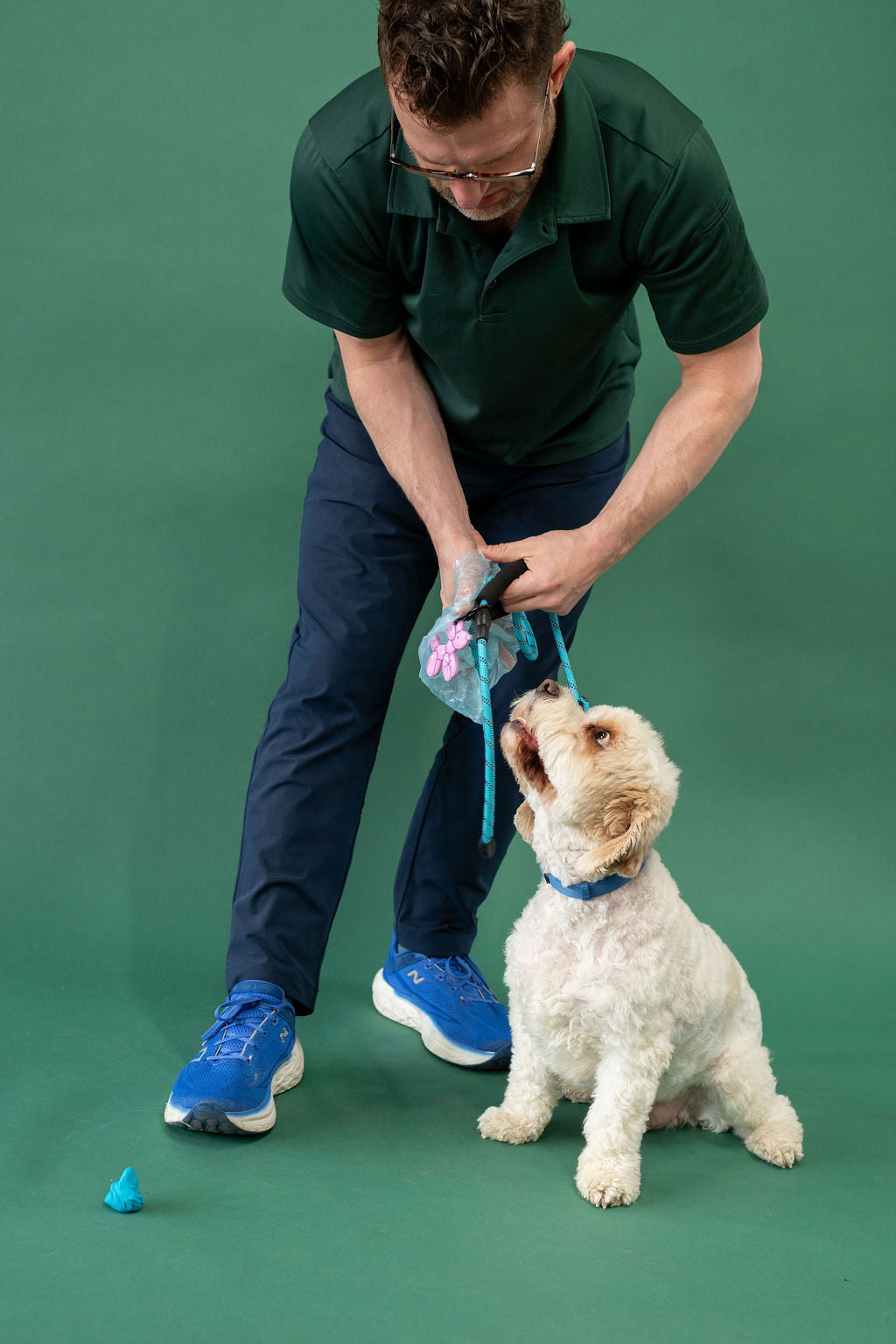 Man and dog interacting with dog poop on a green background
