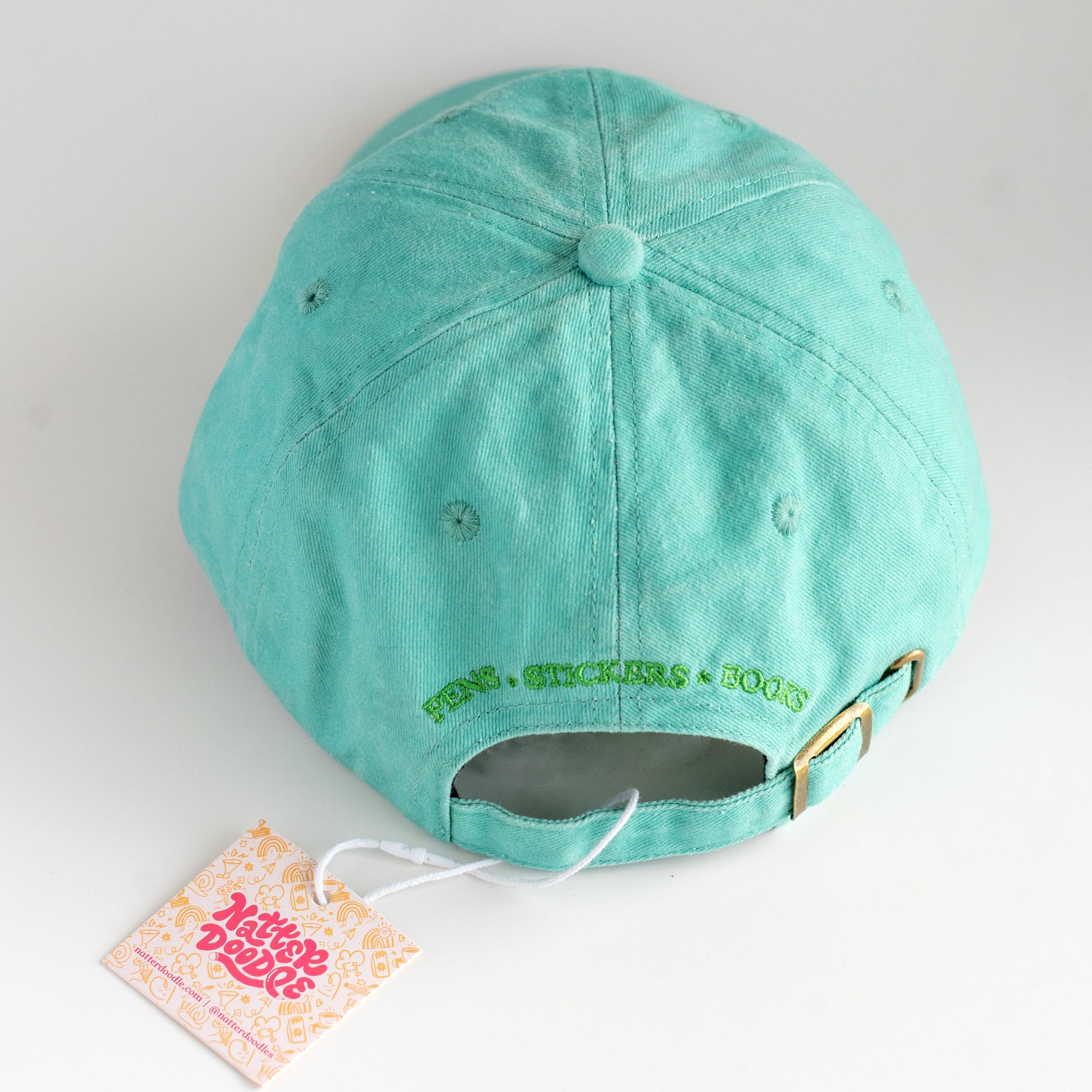 Teal cap with a tag on a white background