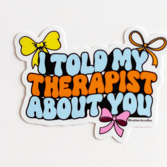 Sticker with text 'I told my therapist about you' and colorful bows on a white background