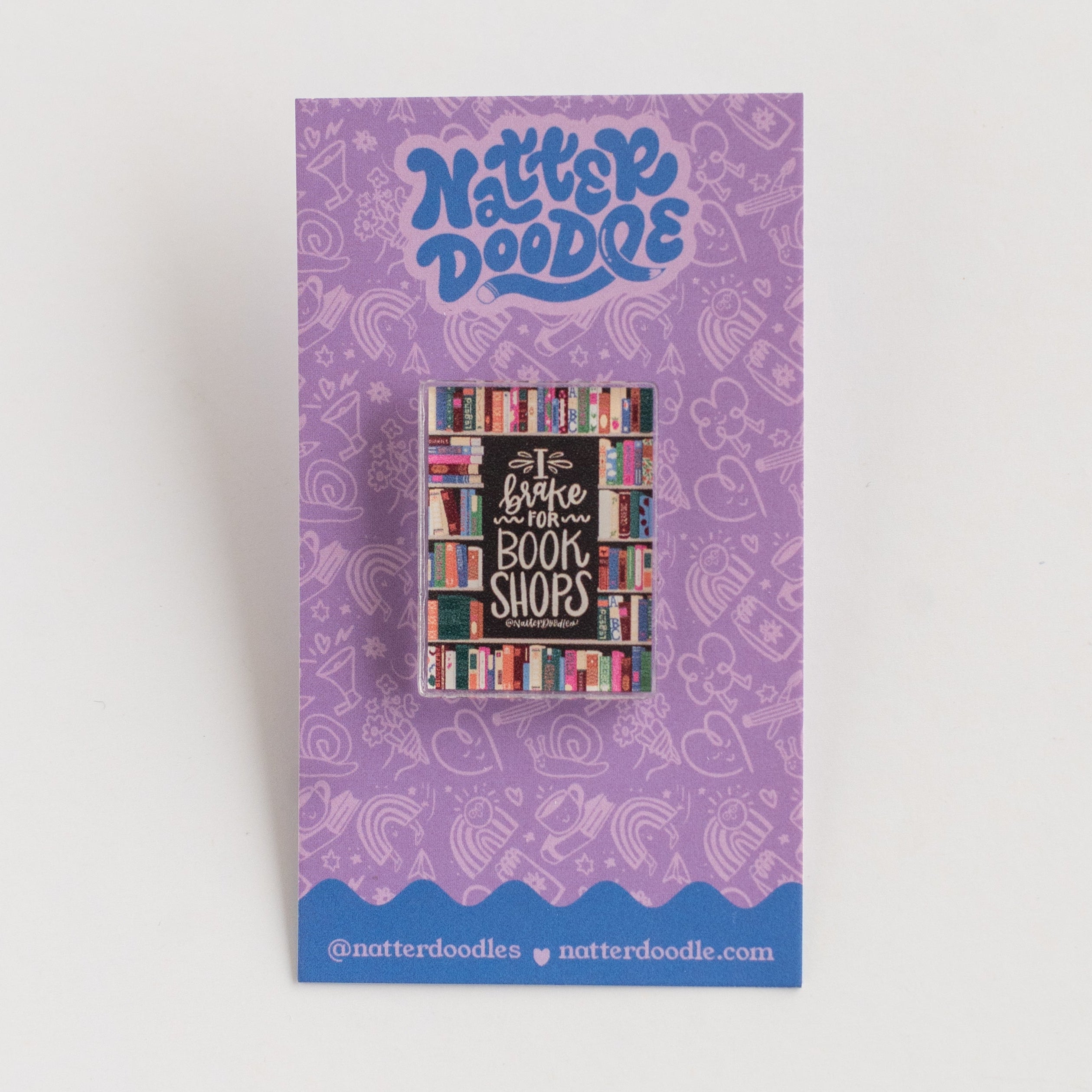 Purple card backer with pin with colorful text and design on a white background