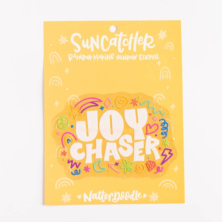 Packaging for 'Joy Chaser' sun catcher with colorful text and designs on a yellow background