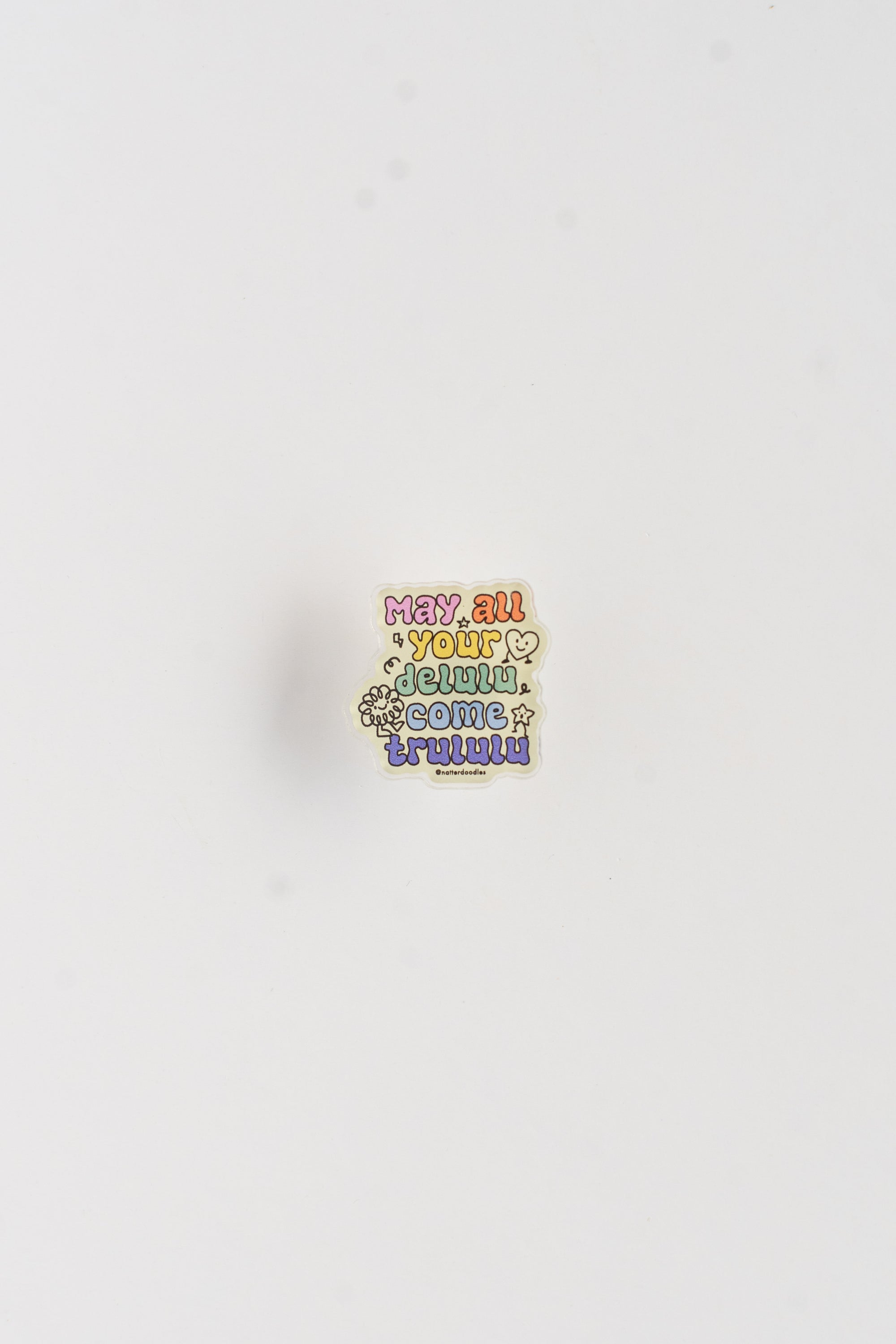Colorful enamel pin with text on a white background