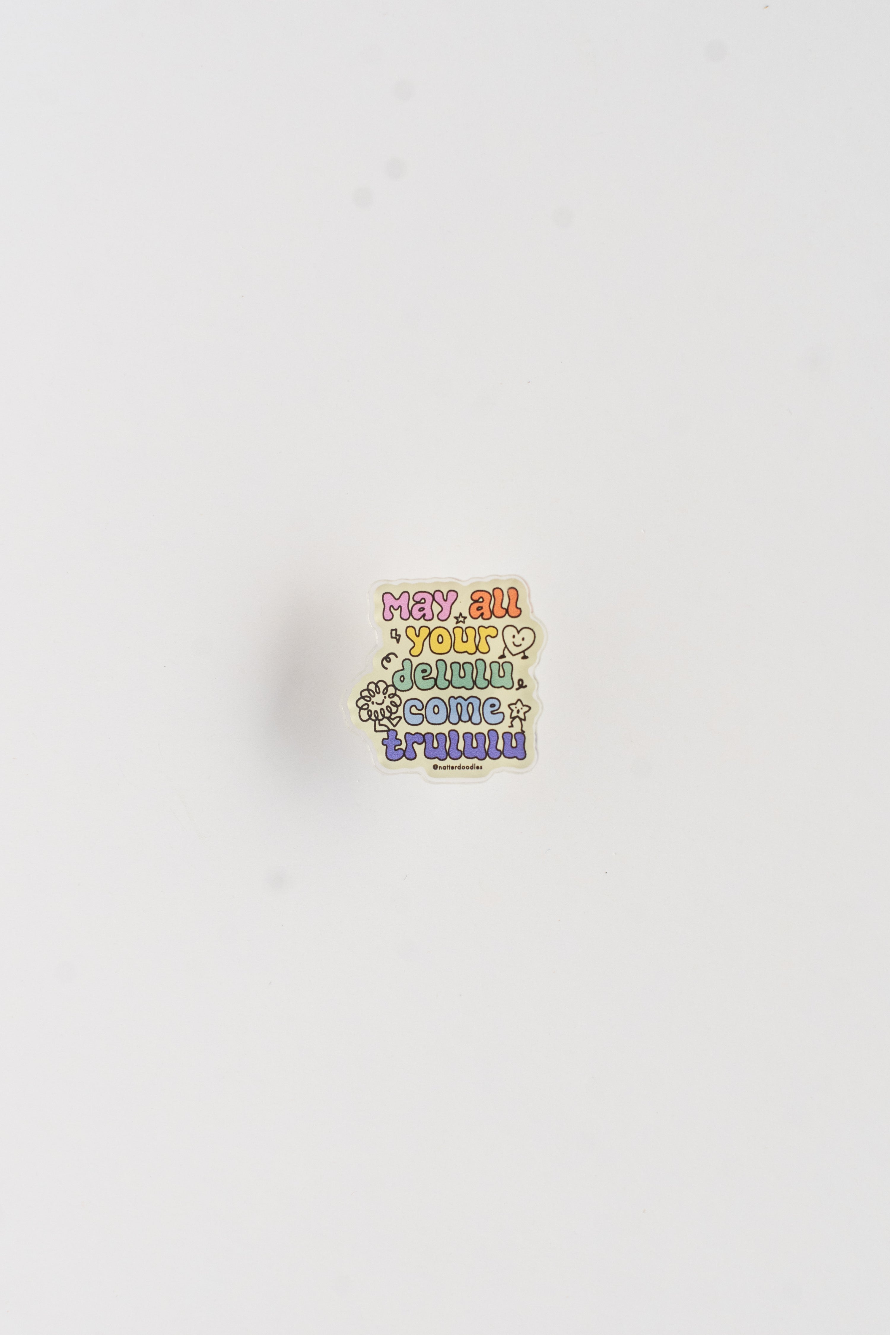 Colorful enamel pin with text on a white background
