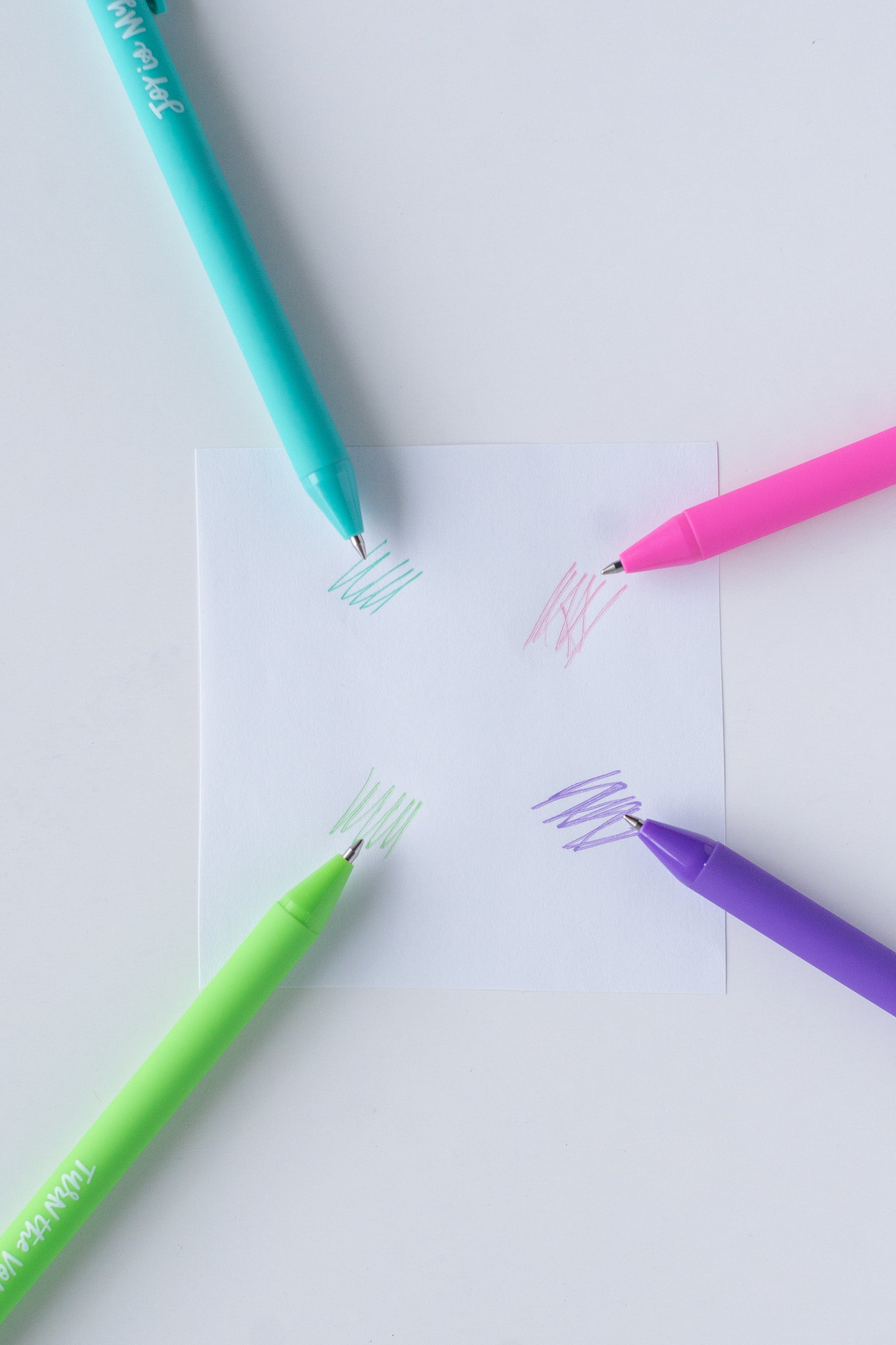 Four colorful markers on a white sheet of paper with samples of colored lines.