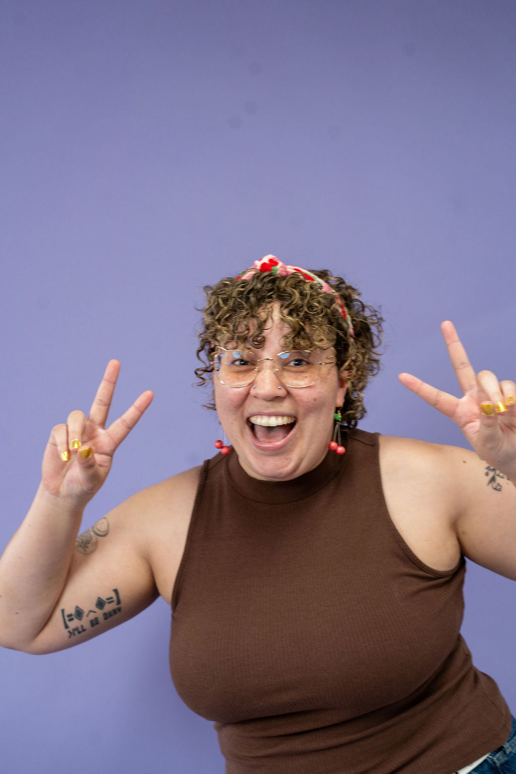 Person wearing a brown tank top against a purple background