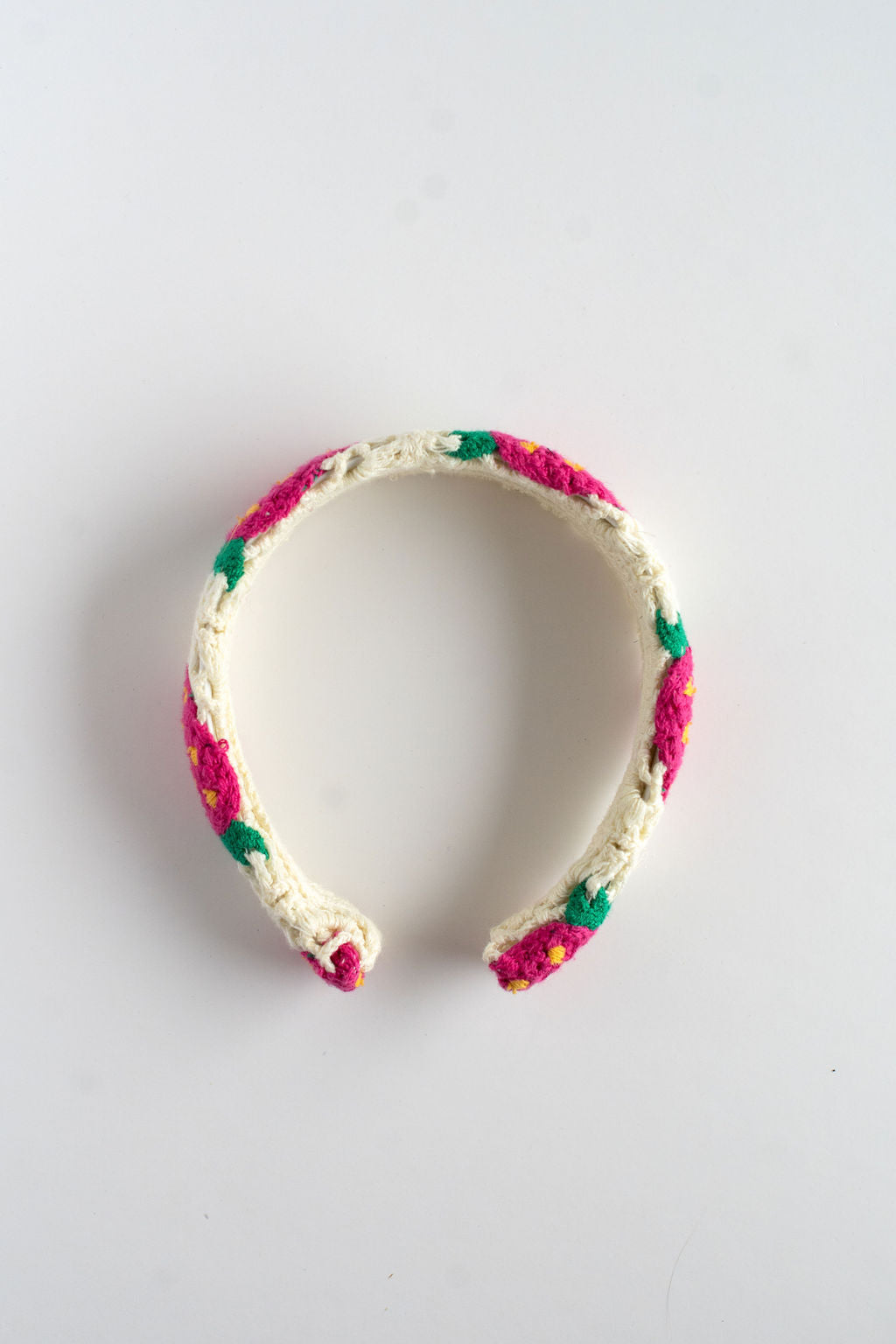 Crocheted headband with colorful yarn on a light gray background
