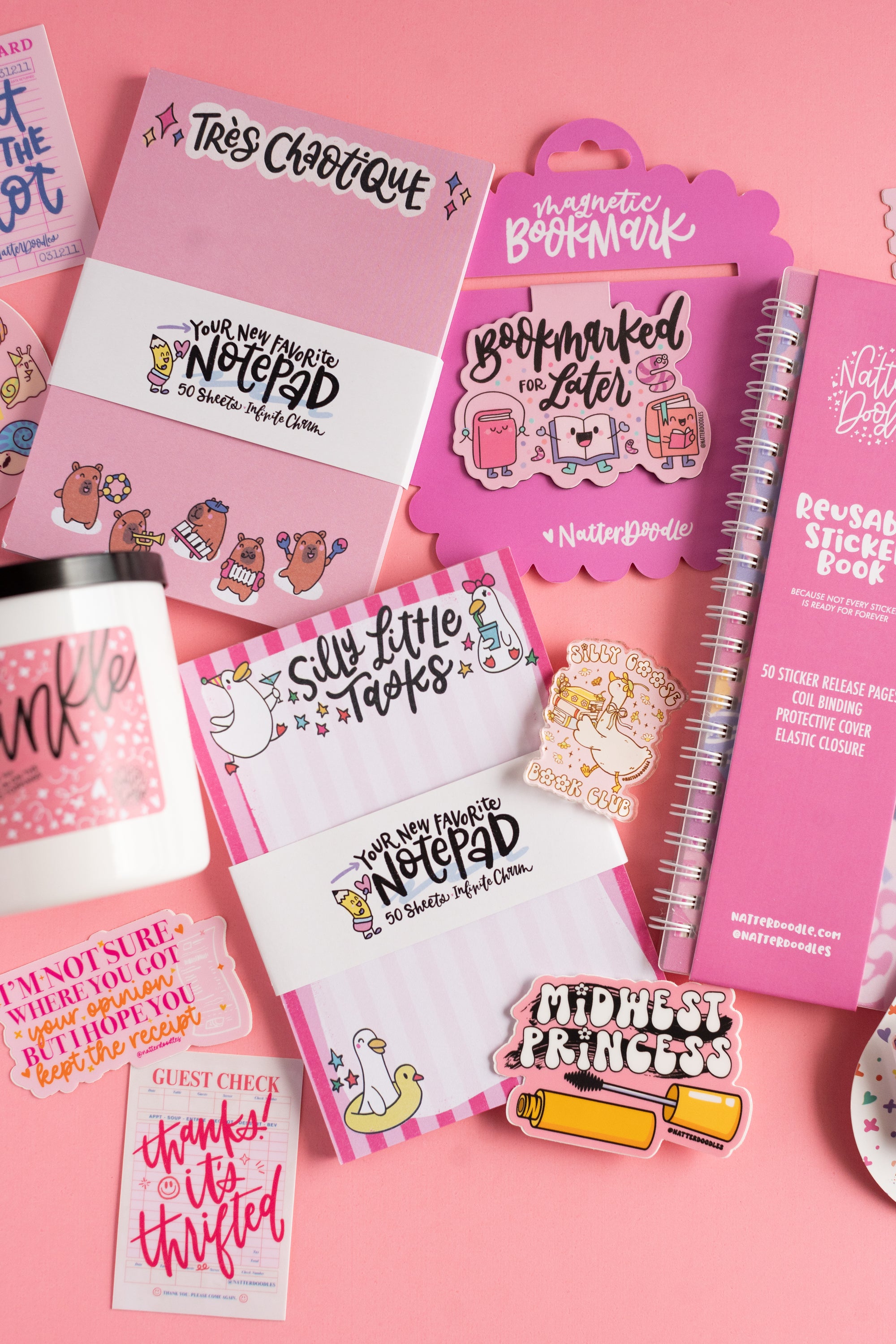 Collection of pink stationery items with text on a pink background