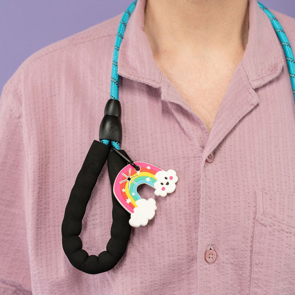 Person wearing a pink shirt with a colorful dog leash attached to their collar.