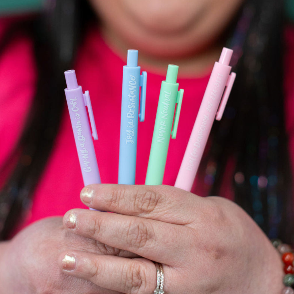 Woman holding colorful pens with a green background