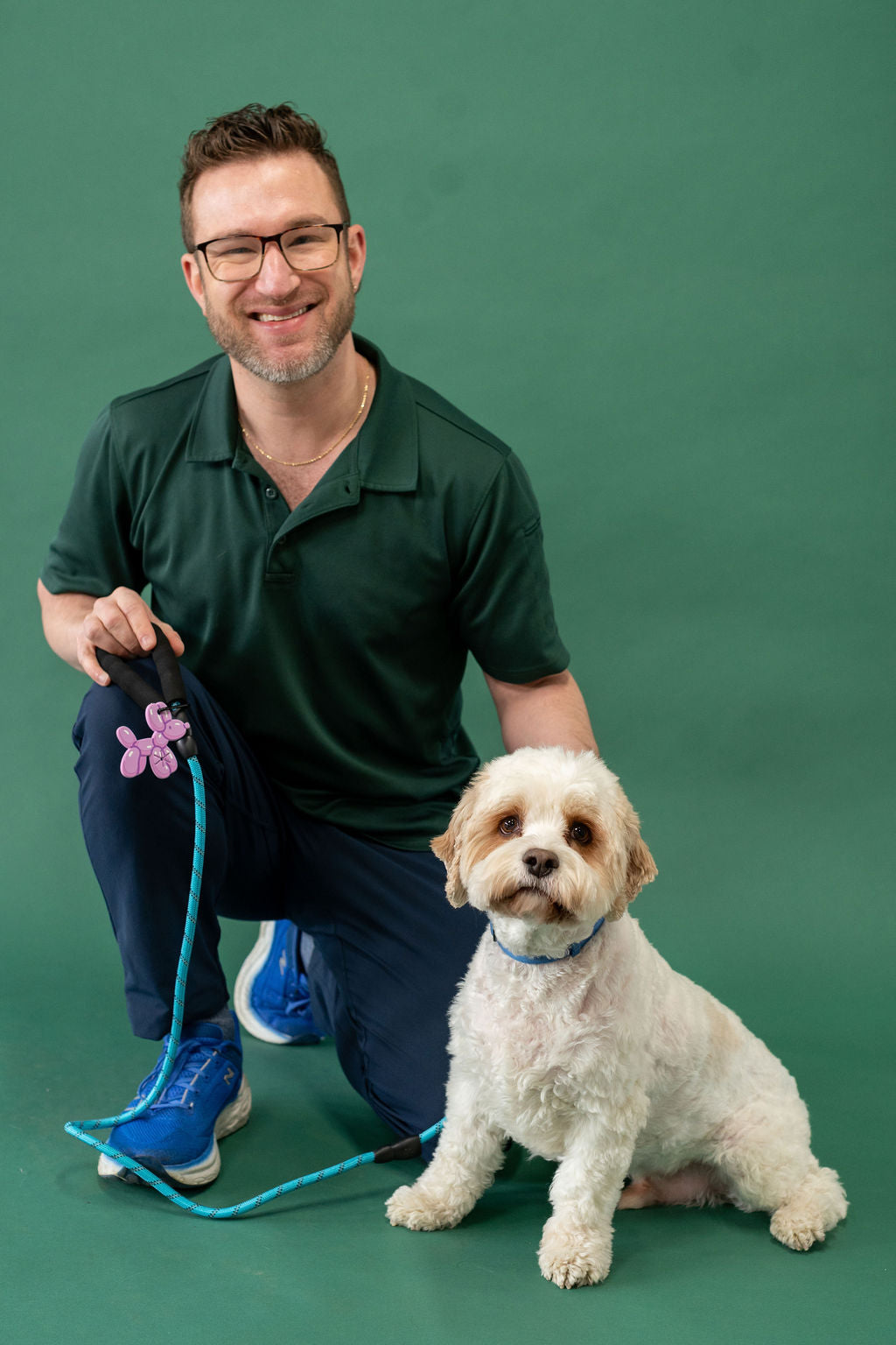 Man with glasses and a dog on a green background