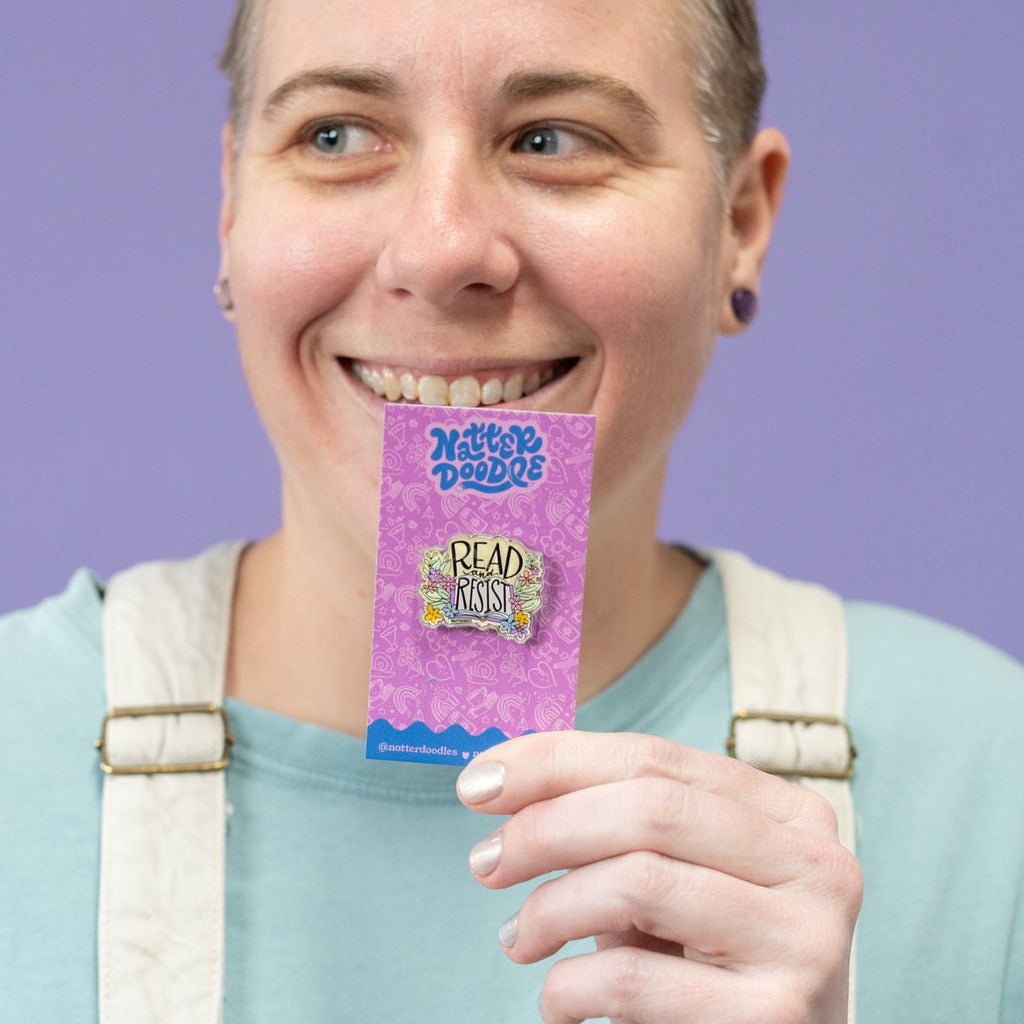 Person holding a purple card with text against a purple background