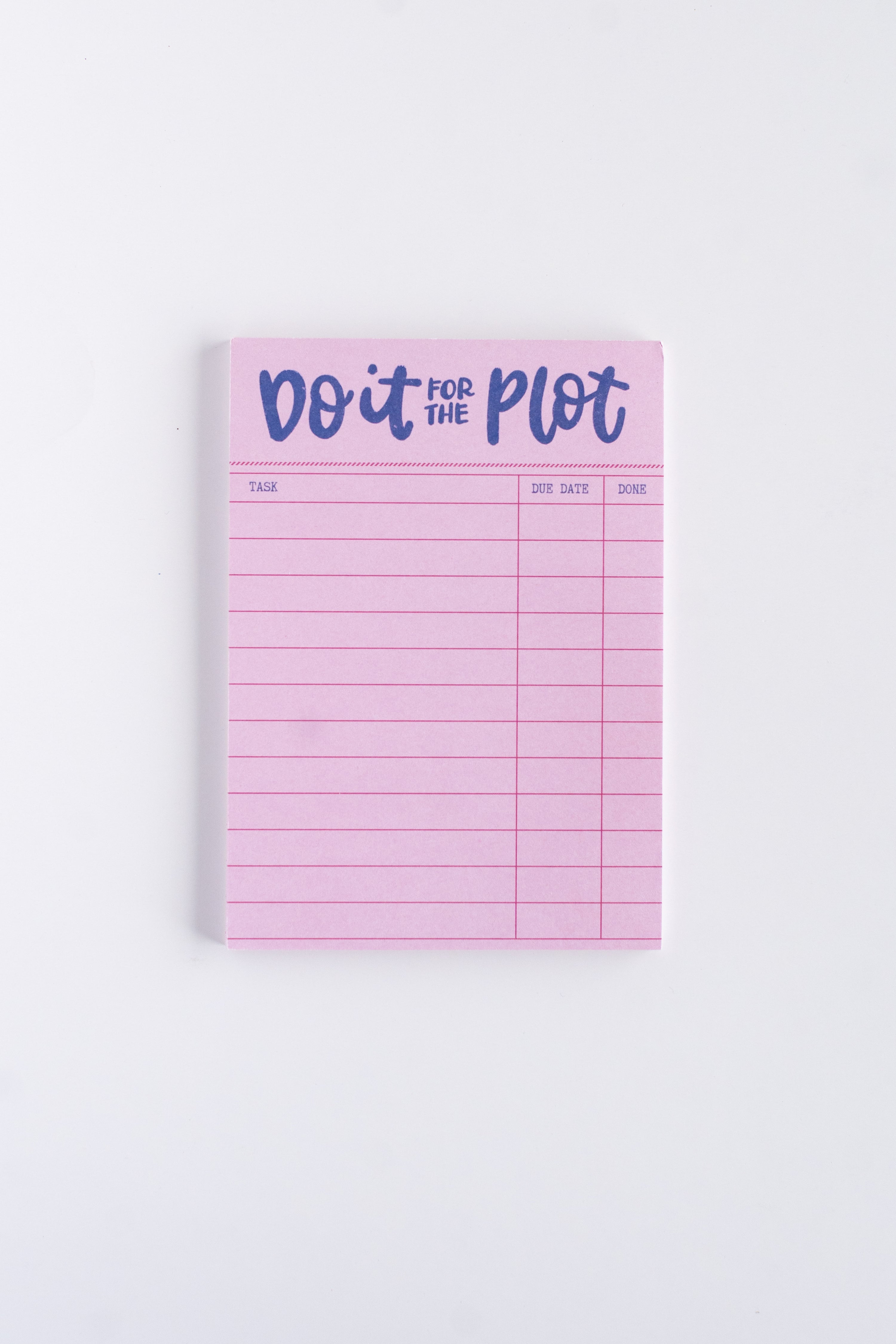Pink notepad with 'Do it for the Plot' text on a white background