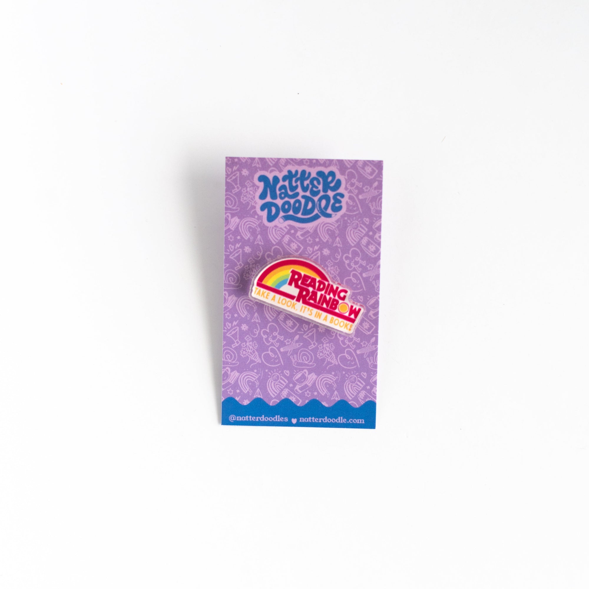 Purple paper with a rainbow pin on a white background