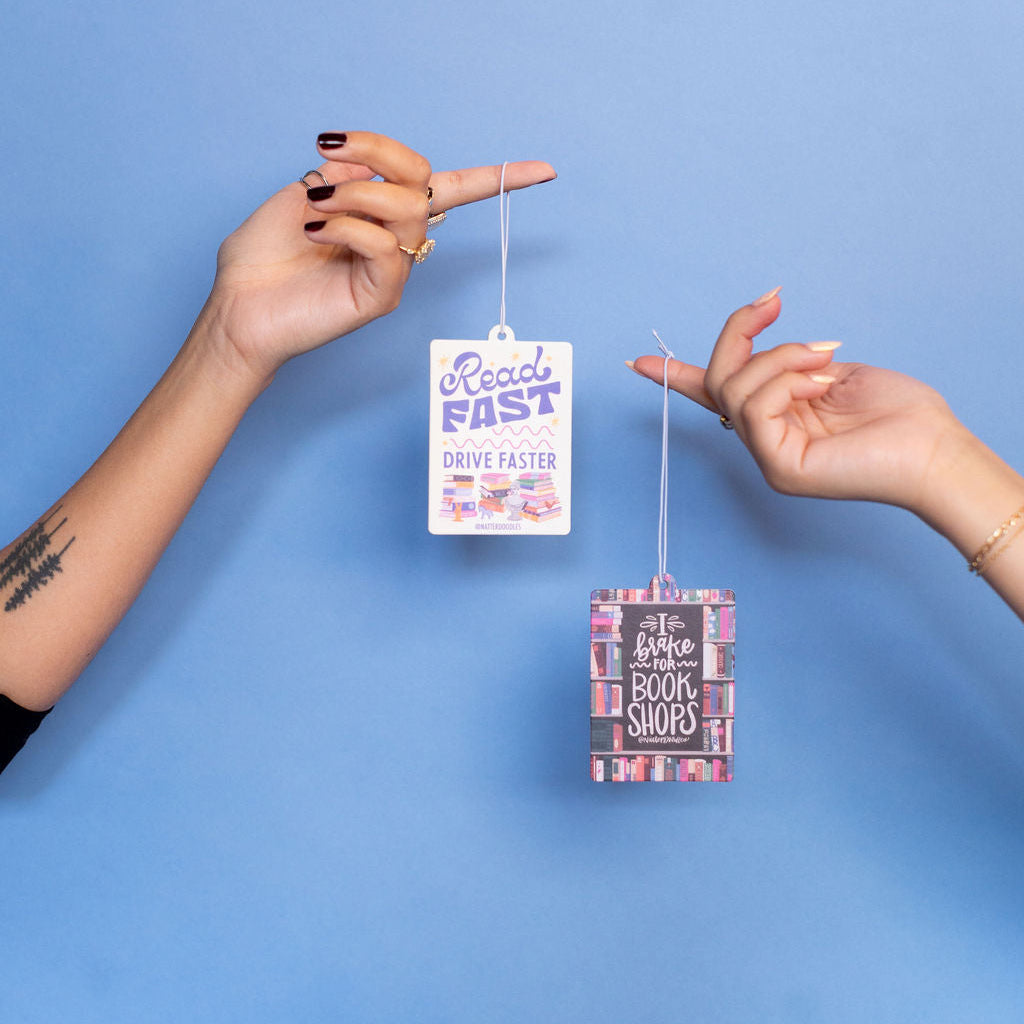 Two hands holding small rectangular signs with text against a blue background