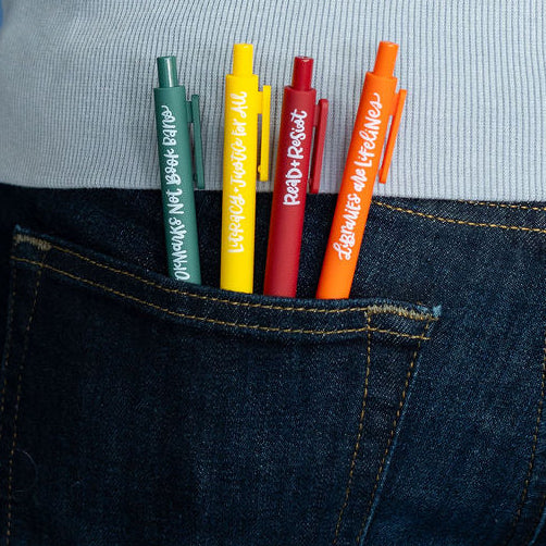 Person wearing a light gray sweater with colorful markers in their back pocket against a blue background