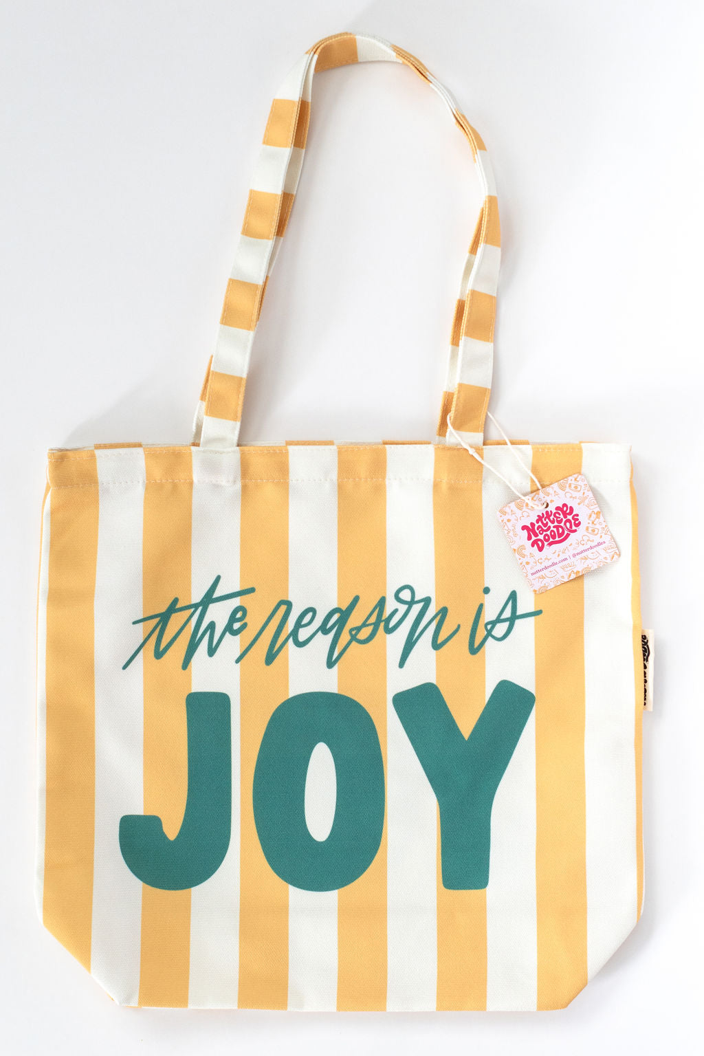 Striped tote bag with 'the reason is JOY' text on a white background
