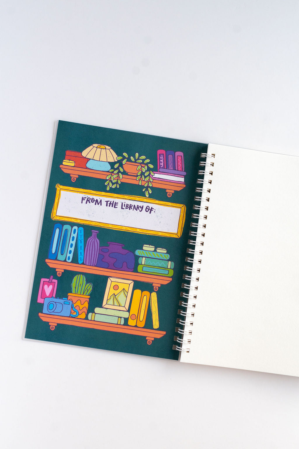 Notebook with colorful illustration of a bookshelf on the  insidecover