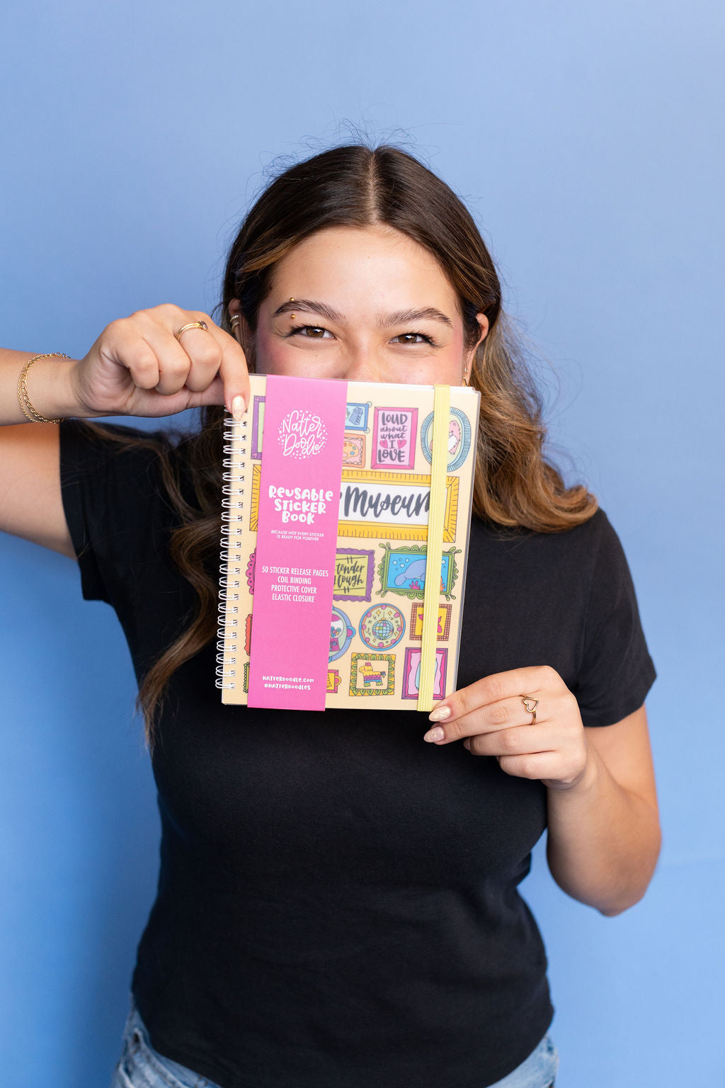Person holding a colorful notebook with a blue background