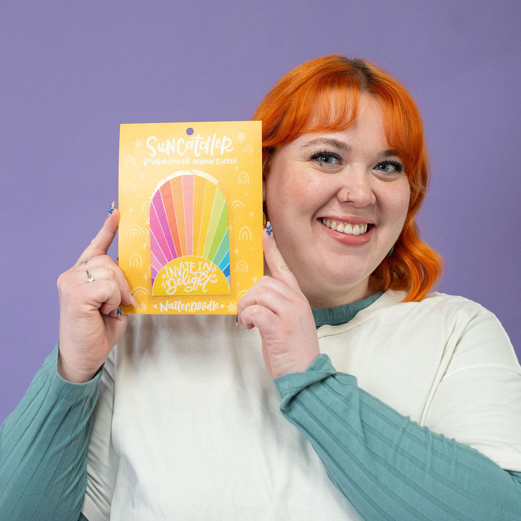 Person holding a colorful product package against a purple background