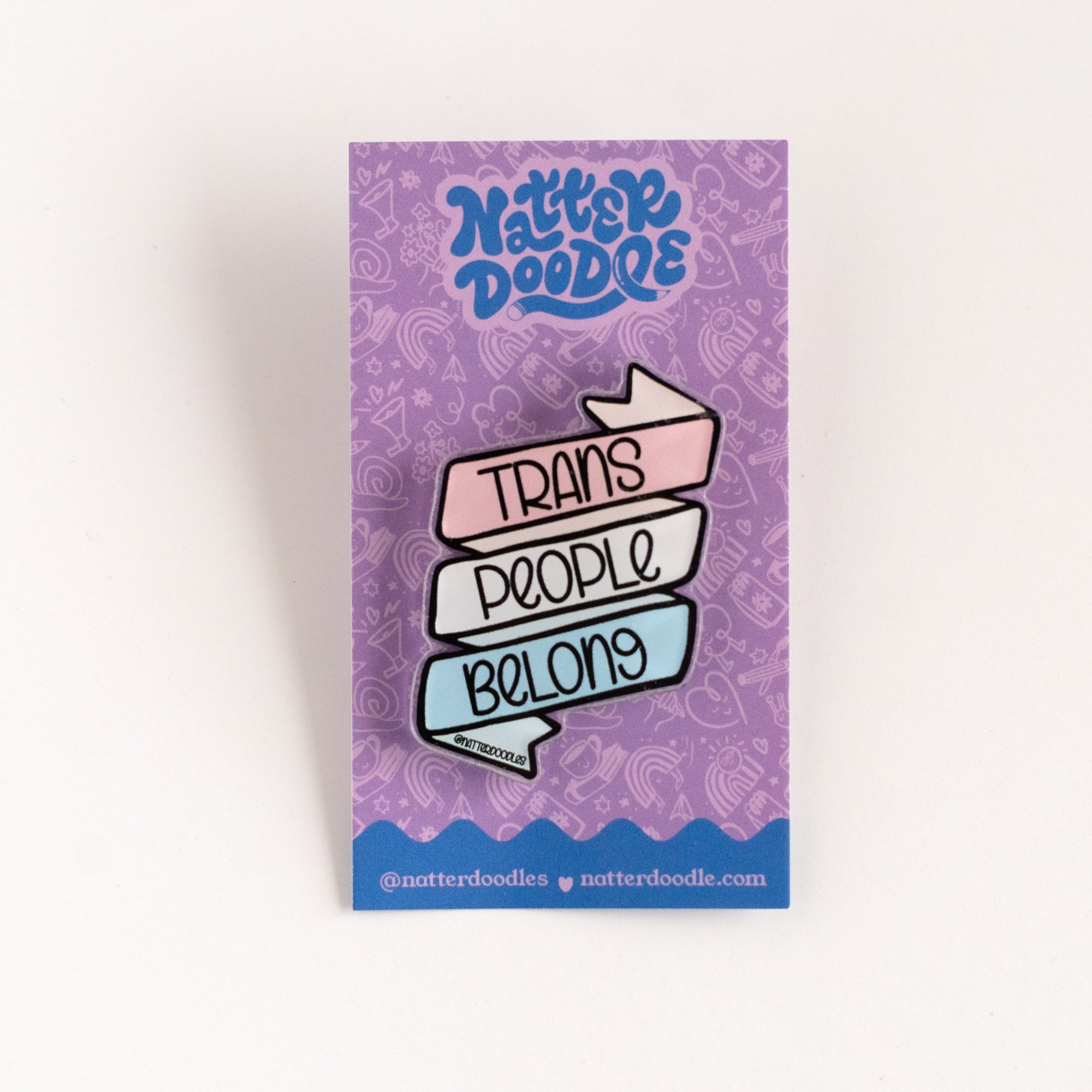 trans people belong lapel pin on purple backing card