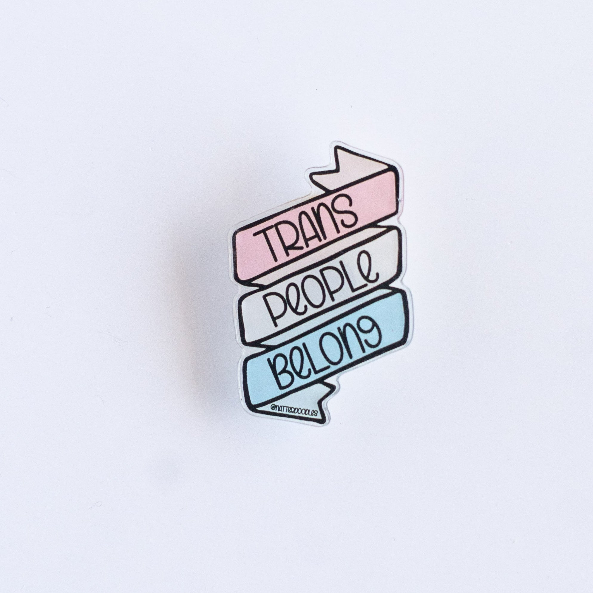 Pin with 'Trans People Belong' text on a light purple background