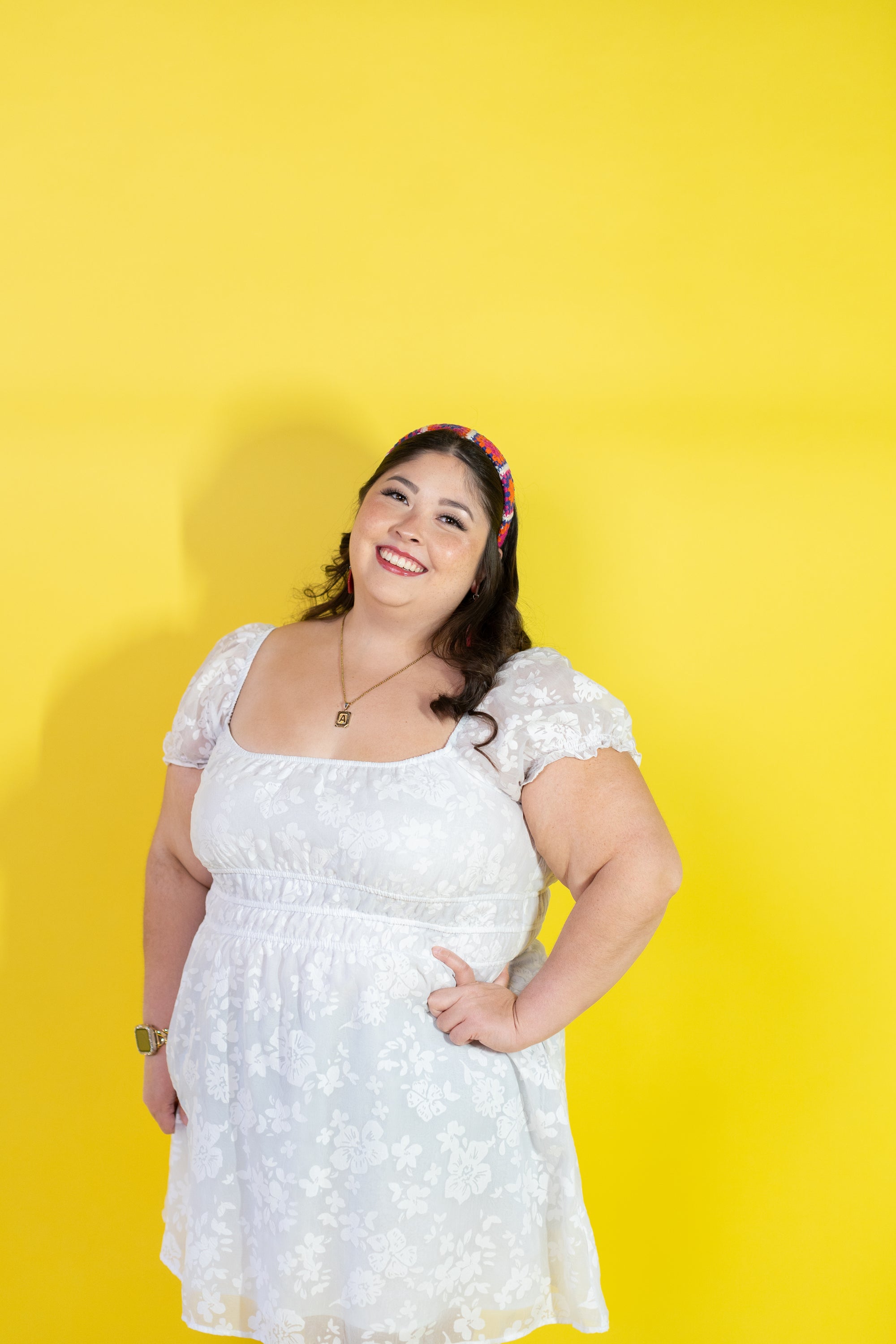 Woman wearing a white dress against a yellow background