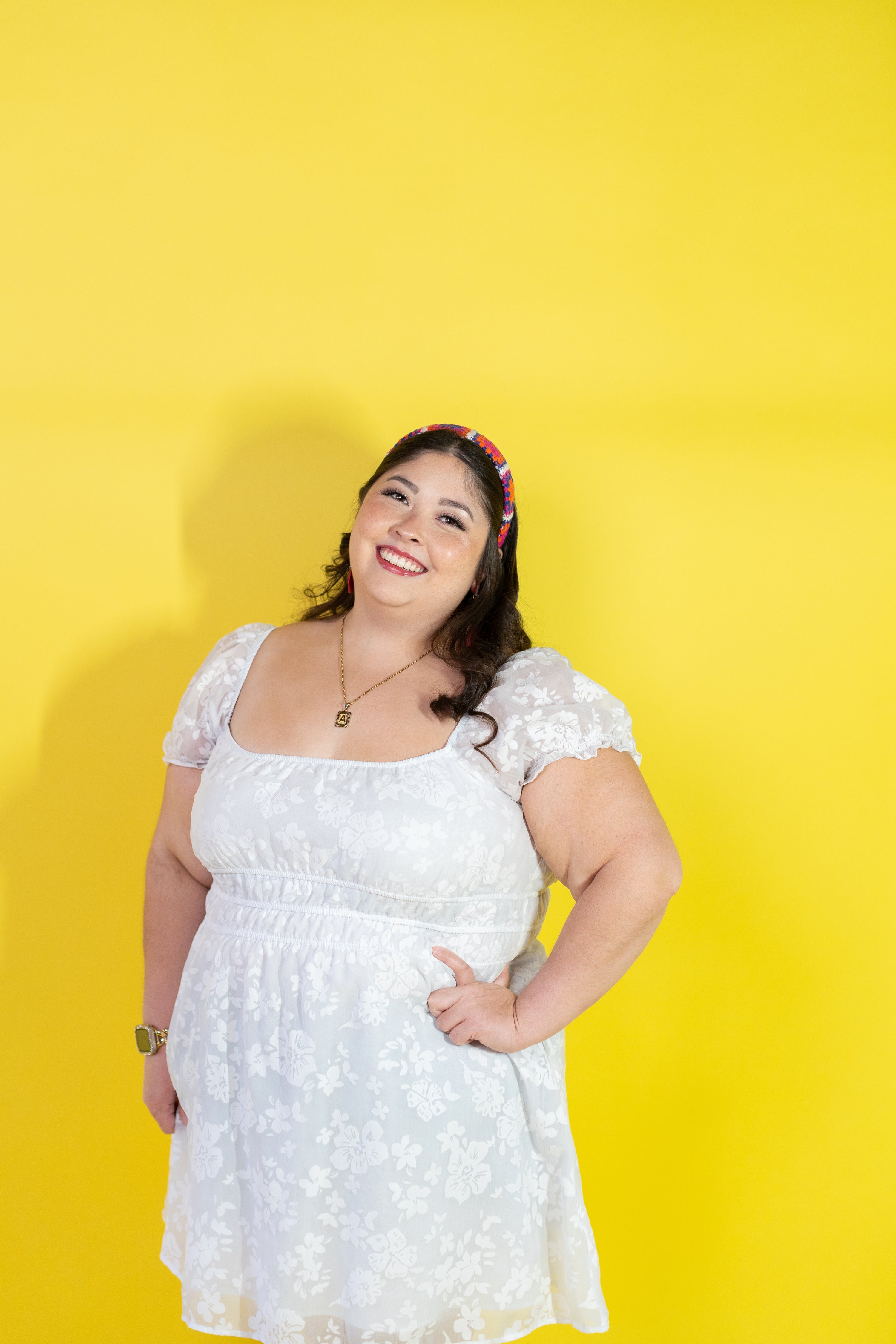 Woman wearing a white dress against a yellow background