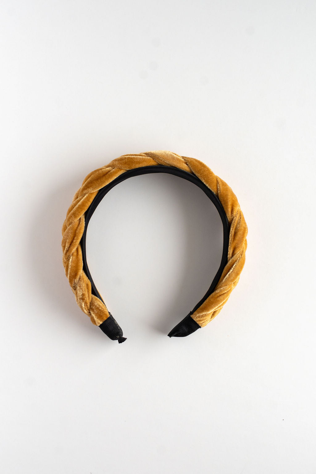 Mustard yellow headband with black accents on a white background